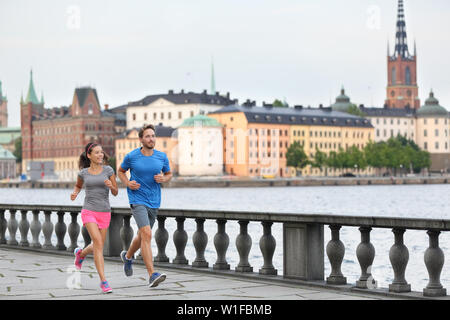 Fit Fitness Übung Menschen, gesunde Läufer in Stockholm City Skyline. Riddarholmskyrkan Kirche im Hintergrund, Schweden, Europa. Gesunde multirassischen asiatische Frau, kaukasische Mann. Stockfoto