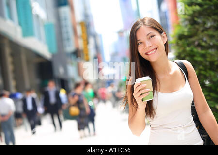 Tokio urbane Frau Pendler gehen Kaffee trinken. Asiatische Fußgängerzone gehen mit der Masse der Leute im Hintergrund in der japanischen Stadt pendeln, in Japan zu arbeiten. Stockfoto