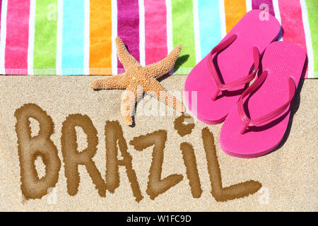 Brasilien Konzept. Ansicht von oben ot das Wort Brasilien am Strand Sand mit einem bunt gestreiften Handtuch geschrieben, pink Tangas und ein Seestern konzeptionelle eines Sommer Urlaub und Reisen in Rio de Janiero, Brasilien. Stockfoto