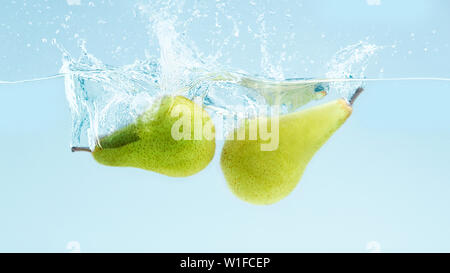Zwei reife Birnen der in Wasser mit Splash Stockfoto