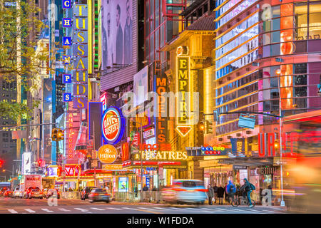 NEW YORK CITY - 14. NOVEMBER 2016: Verkehr bewegt sich unterhalb der beleuchtete Schilder von der 42. Straße. Die Sehenswürdigkeit Straße ist die Heimat von zahlreichen Theatern, Geschäften, Stockfoto