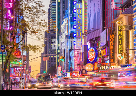 NEW YORK CITY - 14. NOVEMBER 2016: Verkehr bewegt sich unterhalb der beleuchtete Schilder von der 42. Straße. Die Sehenswürdigkeit Straße ist die Heimat von zahlreichen Theatern, Geschäften, Stockfoto