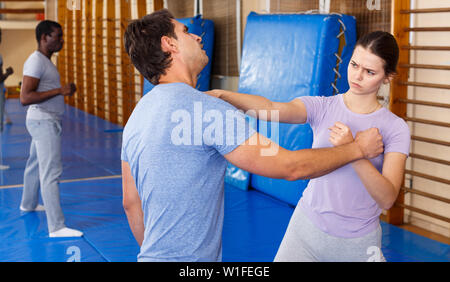 Junger Mann und Frau an selbstschutz Workout, training Angriff Bewegungen im Paar Stockfoto