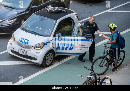 NYPD Officers ein Ticket für einen Radfahrer auf unbestimmte Verletzung im Fahrrad Lane auf 9. Avenue im New Yorker Stadtteil Chelsea am Donnerstag, 27. Juni 2019. (© Richard B. Levine) Stockfoto