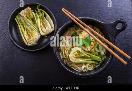 Heiße Thai-Curry-Hühnersuppe mit Pak choi und Pilzen Stockfoto