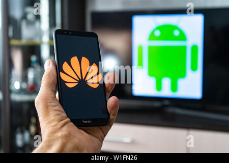 Magdeburg Deutschland - Juni 2019: ein Mann hält ein Android Smartphone Ehren. Auf dem Bildschirm, die huawei Logo vor der Android Logo. Google beschränken Stockfoto