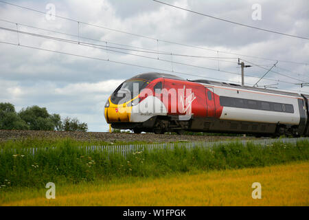 Jungfrau Klasse 390 Pendolino Zug auf das Northampton Schleife der West Coast Main Line an einem sommerlichen Abend Stockfoto