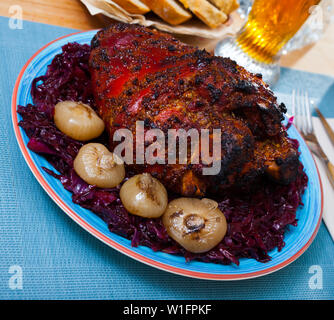 Appetitlich würzig gebackenes Schweinefleisch Schaft mit gemüsegarnitur von geschmorten Rotkohl serviert. Stockfoto