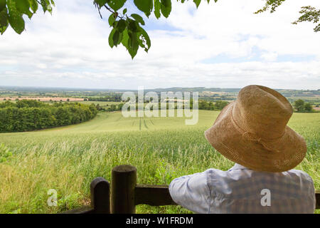 Englische Landschaft im Sommer - eine Frau trägt einen Strohhut auf Aylesbury Vale in Richtung Princes Risborough, Buckinghamshire UK Stockfoto