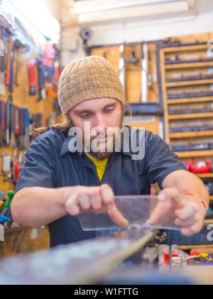 Gut aussehender bärtiger Kerl Basteln in der Werkstatt Stockfoto