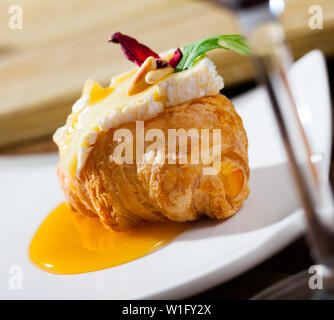 Zarte französische Mini Croissant mit Camembert Slice, Honig, gerösteten Pinienkernen garniert mit frischem Rucola und getrockneten Hibiscus Stockfoto