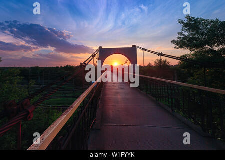 Eine Brücke über die Eisenbahn an einem schönen hellen bewölkter Sonnenuntergang Hintergrund in Kriwoi Rog, Ukraine Stockfoto