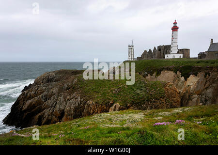 Der Leuchtturm und Abtei steigen über das Meer und die felsige Küste am Pointe Saint-Mathieu in der Bretagne, Frankreich Stockfoto