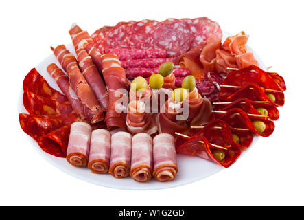 Traditionelle spanische Fleischplatte geschnittenes Trocken - Schinken, Speck und Würstchen auf runder Servierteller mit Oliven geheilt. Auf weissem Hintergrund Stockfoto