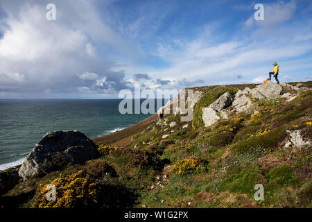 Junge in gelber Jacke stehend auf dem Rock, Pointe de Dinan, Bretagne, Frankreich Stockfoto