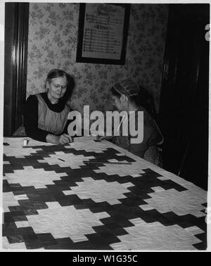 Lancaster County, Pennsylvania. Diese beiden Frauen sind in der Kirche Amish Quilt engagiert. Quilting Bee. . .; Umfang und Inhalt: Die Bildunterschrift lautet wie folgt: Lancaster County, Pennsylvania. Diese beiden Frauen sind in der Kirche Amish Quilt engagiert. Quilten Bienen sind beliebt in diesem Bereich. Beachten Sie die beleuchteten Familie Datensatz an der Wand. Stockfoto