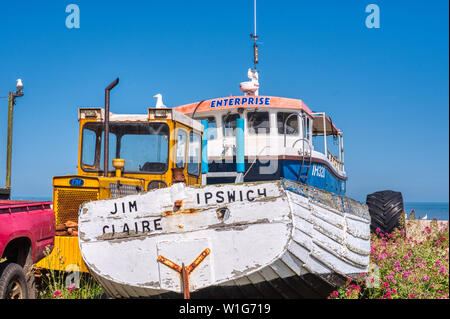 Fischerboot und Bulldozer auf der Kiesstrand in Aldeburgh, Suffolk, Großbritannien Stockfoto