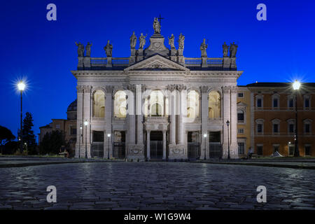 Basilika San Giovanni in Laterano, Hauptfassade. Übernachtung mit Blick auf die Lichter der Stadt und die blaue Stunde Himmel. Stockfoto