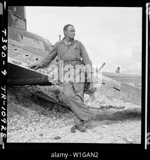 Leutnant Paul Dorsey ein Marine Corps Fotograf an Comndr. Edward Steichen's Naval Aviation fotografischen steht neben einer ruinierten Jap Ebene auf Guam. Stockfoto