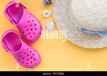 San Diego, USA, 10. Mai 2019. Flach Zusammensetzung mit Badeschuhen, Hut, Muscheln und Platz für Text auf gelbem Hintergrund. Sandalen mit Seashell Stockfoto