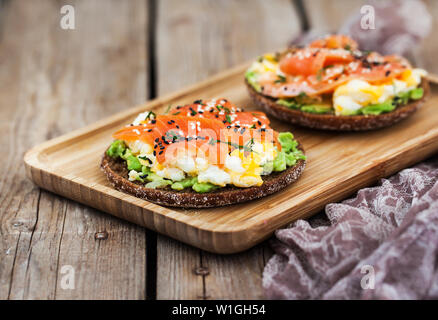 Geräucherter Lachs, Rührei und Avocado Roggen scharfe Toast Stockfoto