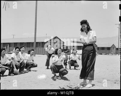 Manzanar Relocation Center, Manzanar, Kalifornien. Maye Noma hinter der Platte und Tomi Nagao bei bat. . .; Umfang und Inhalt: Der vollständige Titel für dieses Foto lautet: manzanar Relocation Center, Manzanar, Kalifornien. Maye Noma hinter der Platte und Tomi Nagao at bat in einem Spiel zwischen den Mitgliedern des Chick-a-Dee weiche Kugel Team, das intakt gehalten wurde, wenn der Spieler von Los Angeles nach Manzanar, einem Krieg Relocation Authority Center für Umsiedler von japanischen Vorfahren evakuiert wurden. Stockfoto