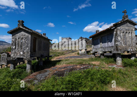 Ansicht der Getreidespeicher (espigueiros) und mittelalterliche Burg im historischen Dorf Lindoso, Portugal. Stockfoto