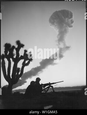 Marines an A-Bombe Tests - zwei Marinen Infanteristen, an einer Maschine Geschützstellung, sind gegen den Himmel während am frühen Morgen A-Bomb Blast, Yucca Flat, Nevada. Dies ist eine der aktuellen Frühling Reihe von Atomtests durch das Verteidigungsministerium im Zusammenhang mit dem Atomic Energy Commission durchgeführt Stockfoto