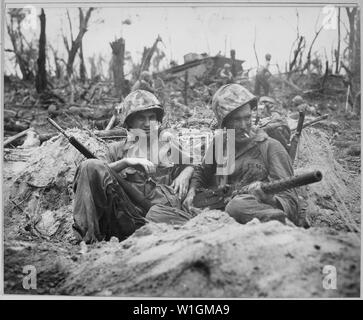 Marine Private First Class Douglas Lightheart (rechts) wiegen eine 30-Kaliber Maschinengewehr auf seinen Schoß, während er und seine Kumpel Private First Class Gerald Churchby, die Zeit für eine Zigarette, und wischen Sie den Feind auf Peleliu Inseln; Allgemeine Hinweise: Verwenden Sie Krieg und Konflikt Nummer 874 bei der Bestellung eine Reproduktion oder Anforderung von Informationen zu diesem Bild. Der Marine auf der linken wurde versuchsweise durch Informationen, die von den nationalen Archiven erhalten als Gerald S. Thursby, Sr. von Akron, Ohio, nicht Gerald Churchby identifiziert. Stockfoto