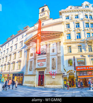 Wien, Österreich - 18. FEBRUAR 2019: Die Fassade der Maltesekirche (Maltesische Kirche) mit Glockenturm auf der Oberseite zwischen Bauten auf Karntne eingeklemmt ist Stockfoto