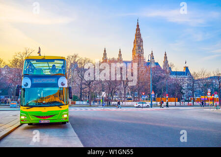 Wien, Österreich - 18. FEBRUAR 2019: Die lustige Doppeldecker Sightseeing Bus, geparkt neben einem der Wahrzeichen der Stadt, dem Rathausplatz w Stockfoto