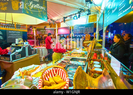 Wien, Österreich - 18. Februar 2019: Der Kaufmann von garküche Grillen traditionellen Würstchen, tha beliebtesten Straße Essen in Österreich, am 18. Februar Stockfoto