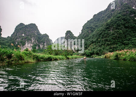 Boot Höhlentour in Trang eine malerische Landschaft von Karst Türme und Pflanzen entlang des Flusses gebildet (UNESCO-Weltkulturerbe). Es ist die Halong Bucht an Land Stockfoto