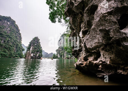 Boot Höhlentour in Trang eine malerische Landschaft von Karst Türme und Pflanzen entlang des Flusses gebildet (UNESCO-Weltkulturerbe). Es ist die Halong Bucht an Land Stockfoto