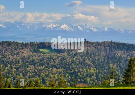 Charmante Feder Berglandschaft. Schneebedeckte Gipfel über die wunderschönen Hügel. Stockfoto