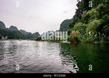 Boot Höhlentour in Trang eine malerische Landschaft von Karst Türme und Pflanzen entlang des Flusses gebildet (UNESCO-Weltkulturerbe). Es ist die Halong Bucht an Land Stockfoto