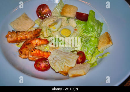 Frische Caesar Salat auf weiße Schüssel mit Parmesan und Garnelen. Ansicht von oben. Stockfoto