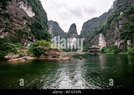 Boot Höhlentour in Trang eine malerische Landschaft von Karst Türme und Pflanzen entlang des Flusses gebildet (UNESCO-Weltkulturerbe). Es ist die Halong Bucht an Land Stockfoto