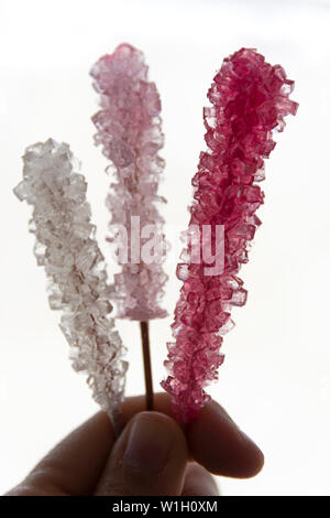 Hand mit cristalized Lollipop mit lebendigen Farben Stockfoto