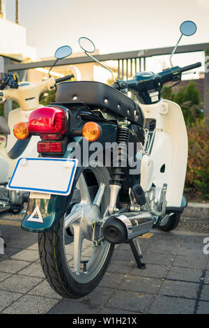 Geparkt vintage Roller auf der Straße. Hintere Ansicht. Schöne klassische an einem sonnigen Tag Moped. Parkplatz am Motorrad Stockfoto