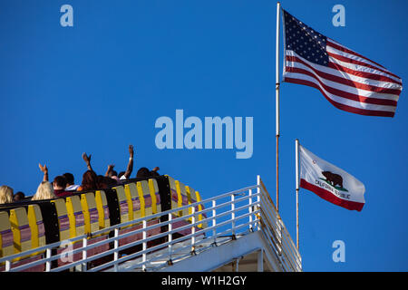 West Achterbahn, Stahl Achterbahnfahrt mit Fahnen auf USA und Kalifornien in Pacific Park Santa Monica Pier, Los Angeles, Kalifornien Stockfoto