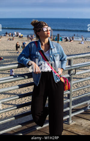 Frau mittleren Alters mit Schattierungen in Santa Monica Beach, Los Angeles, Kalifornien posing Stockfoto
