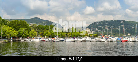COMO, ITALIEN - JUNI 2019: Blick auf Segelboote und Motorboote im Hafen von Como am Comer See. Stockfoto