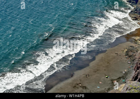 Das türkis-blauen Atlantik mit weißen Wellen in einem diagonalen Schnitt mit einem grauen schönen Strand von weit oben fotografiert. Auf Teneriffa in Igueste de San Stockfoto