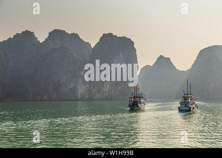 Ha Long Bay, Vietnam - Dezember 24, 2013: Schöne Aussicht auf touristische Boote unter Kalksteinfelsen von Ha Long Bay, Vietnam Stockfoto