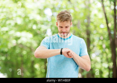 Smart Fitness. Passen Athlet tracking seine Fitness mit Sport Watch. Schöner Athlet mit Fitness Tracker beim Training im Freien. Seine Gesundheit Überwachung mit der besten Fitness Gerät. Stockfoto