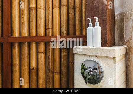 Zwei Flaschen Shampoo und Duschgel im Auenbereich tropische Dusche auf  Holz Bambus Hintergrund. Bali Stil. Eco-Konzept Stockfotografie - Alamy