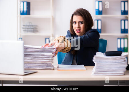 Junge schöne Mitarbeiter gebunden mit Seil im Büro Stockfoto