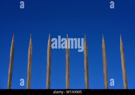 Stahl zaun Barriere mit spitzen Bars gegen den blauen Himmel. Konzept der Einsamkeit hineingetrieben, Hindernis, hier finden sie Schutz Stockfoto