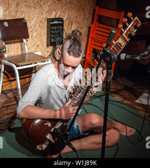 Junge kaukasier Musiker spielt eine Sitar Stockfoto
